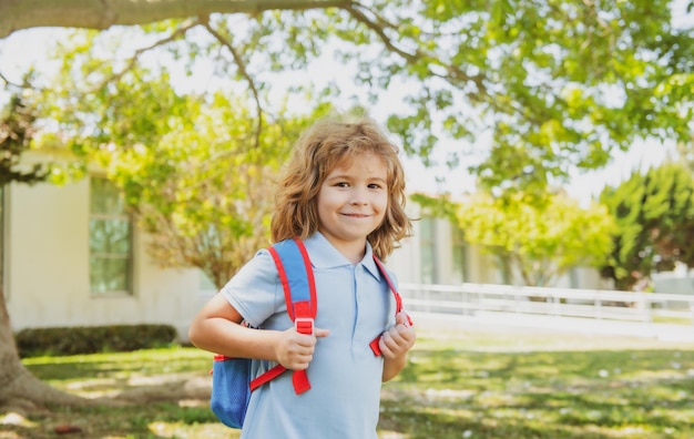 Kid with backpack going to school kids education concept child with rucksacks standing in the park n