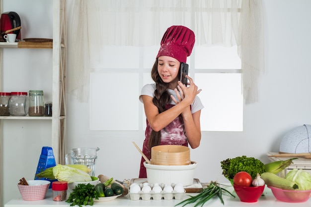 Kid with flour and eggs cooking in kitchen culinary