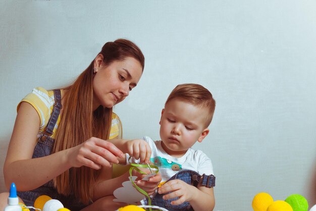 Kid with mother color eggs for easter