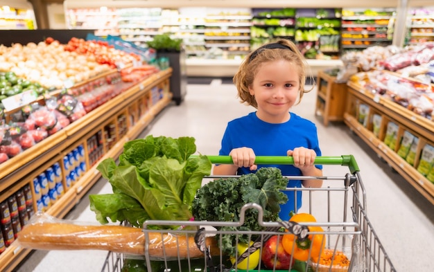 Kid with shopping cart at grocery store Child buying fruit in supermarket Little boy buy fresh vegetables in grocery store Kid choosing vegetables Healthy food