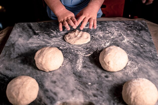 Kid39s hands dough for pizza on the marble table