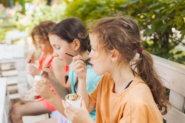 The kids are eating ice cream in the outdoor cafe