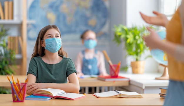 Kids are wearing facemasks learning in class