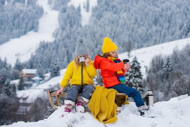 Kids boy and little girl enjoying a sleigh ride children sibling together sledding play outdoors in