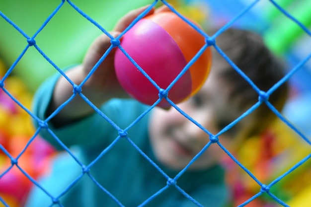 Kids or boy playing inside a playground ball pool area