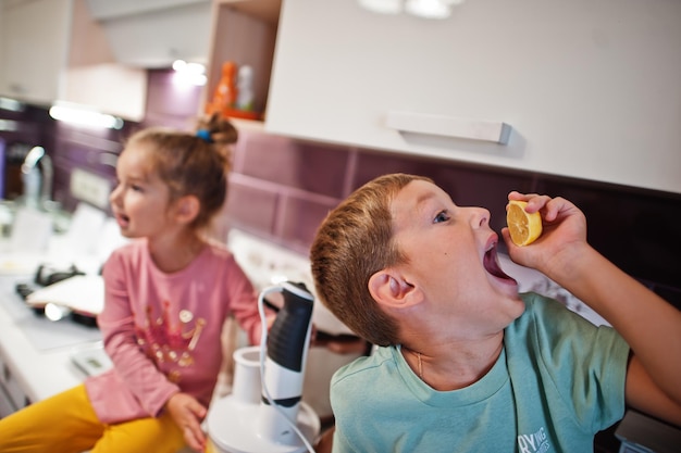 Kids cooking at kitchen happy children's moments Boy eat a lemon