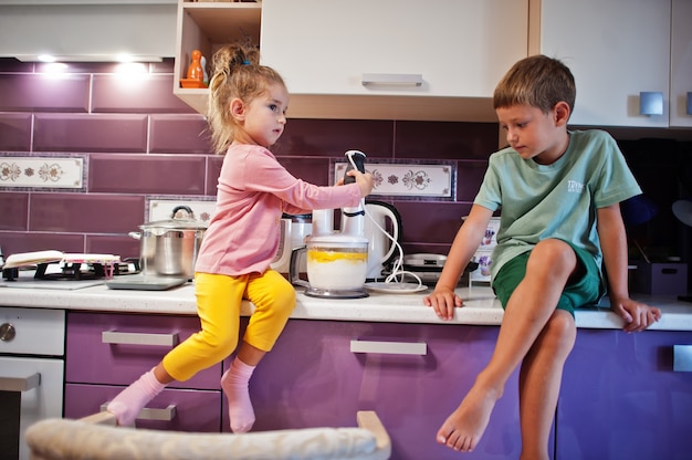 Kids cooking at kitchen, happy children's moments.