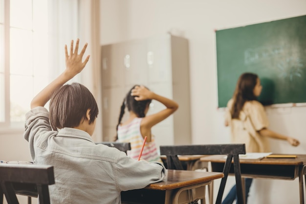 Kids education in the school class room boy hand rise for asking teacher problem