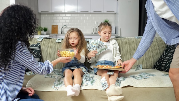 Kids enjoy sitting among money and receive food from parents