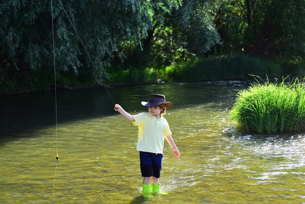 Kids Fishing Little kid pulling fishing rod while fishing on weekend Fisherman in a hat Cute boy is