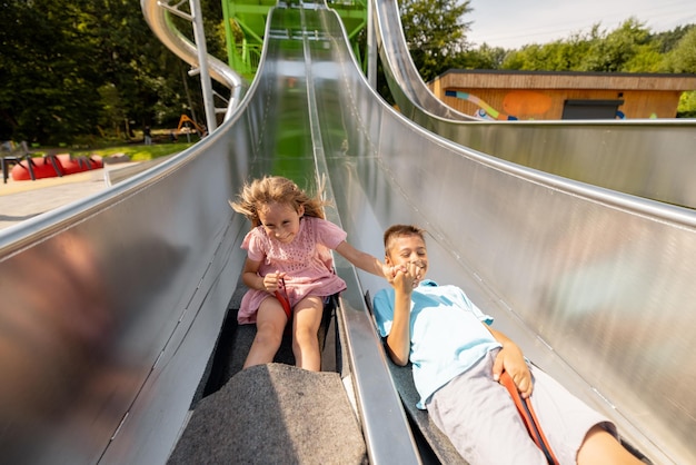 Kids go down a childrens high slide at amusement park