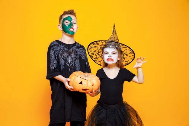 Kids in Halloween Costumes Playing with Pumpkin