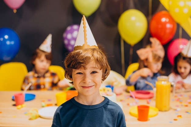 Kids having fun at birthday party with balloons and cake