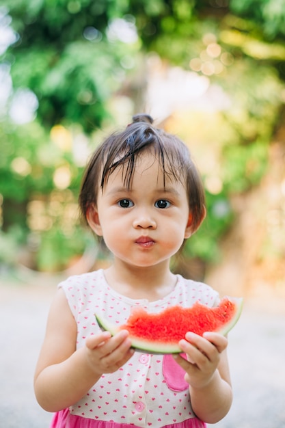 kids having fun and celebrating the hot summer holidays by eating watermelon