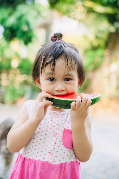 kids having fun and celebrating the hot summer holidays by eating watermelon