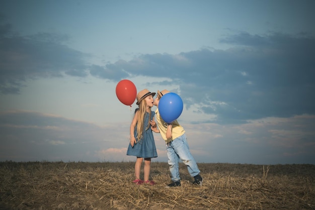 Kids having fun in green field against sky valentines day cupid child happy valentines day love conc...