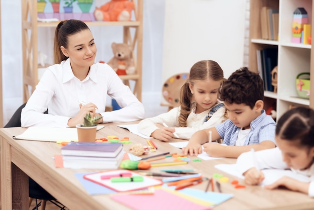 Kids in Kindergarten learn to draw with pencils.