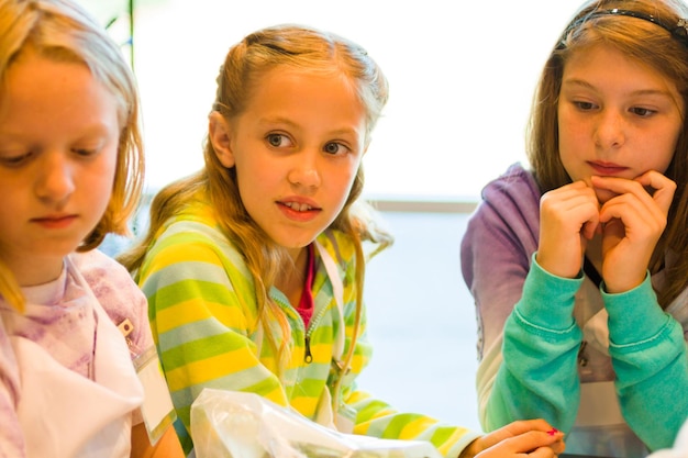 Kids learning how to cook in a cooking class.