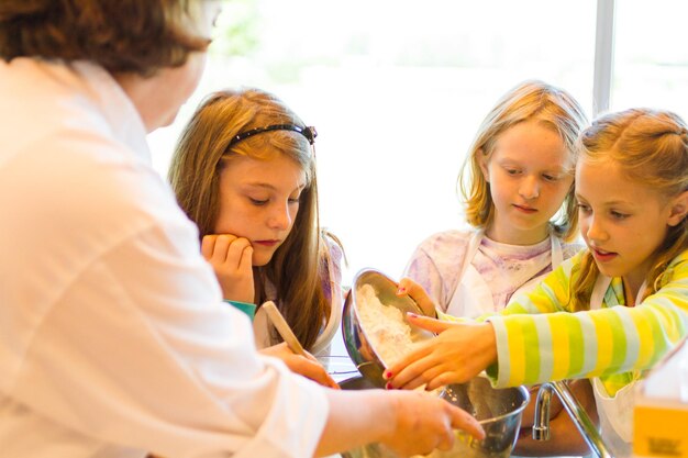 Kids learning how to cook in a cooking class.