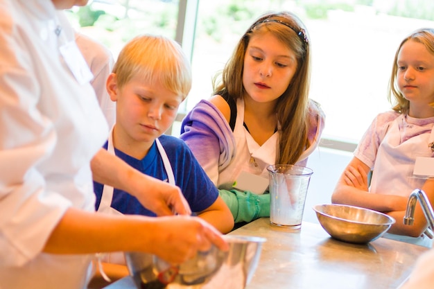 Kids learning how to cook in a cooking class.