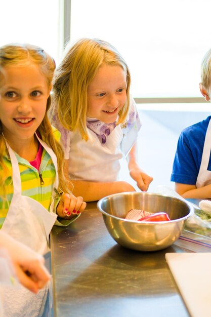 Kids learning how to cook in a cooking class.