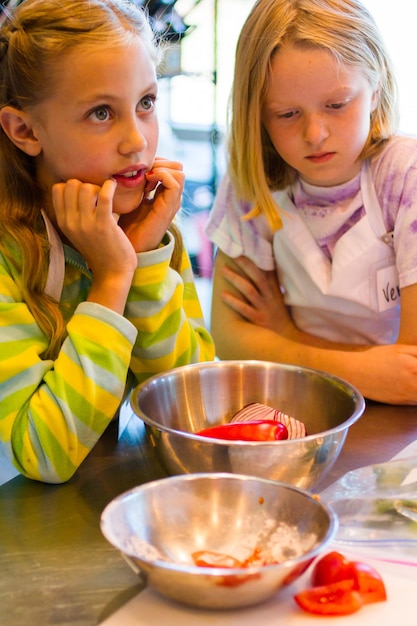 Kids learning how to cook in a cooking class.