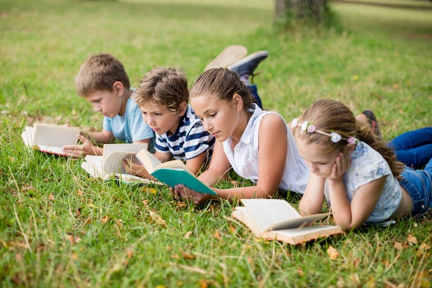 Kids lying on grass and reading books