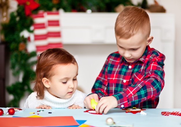 Kids making decor for Christmas tree or gifts. Christmas handmade diy project.