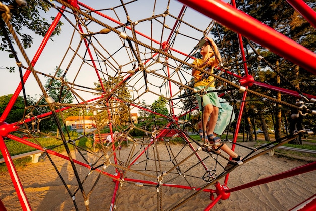 Kids play in rope polyhedron climb at playground outdoor