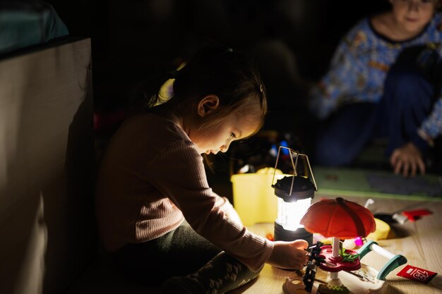 Kids playing at home during a blackout using led lantern