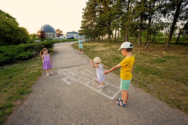 Kids playing hopscotch in park Children outdoor activities