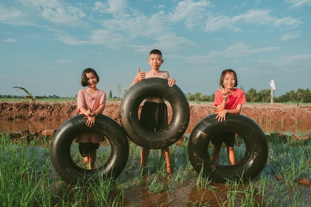 Kids playing and swimming in canal of organic farm in countryside