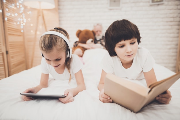 kids reading a book on bed