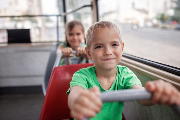 Kids ride in empty tram and look at the window with smile public transportation city tramway