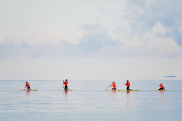 Kids surf school at blue sea children with teacher on surfboards heading for the surf in uniform