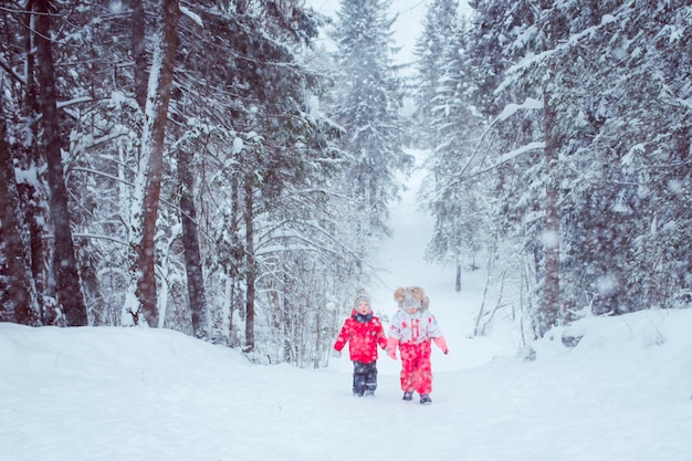 kids walk in snow forest