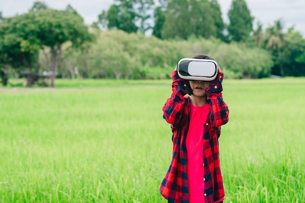 Kids wearing virtual reality video glasses and joyful in beautiful nature background