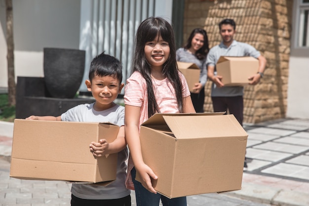 Kids with cardboard box standing in front of the house