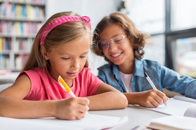 Kids writing their homework in the library