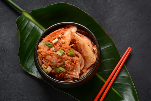 Kimchi and rice in black bowl with chopstick Korean food