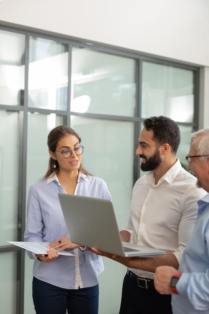 Kind bearded man holding laptop while looking at his partner