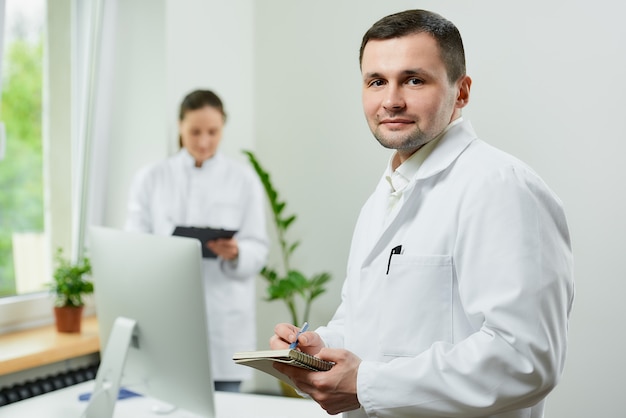 Photo kind caucasian doctor with a notebook and a pen