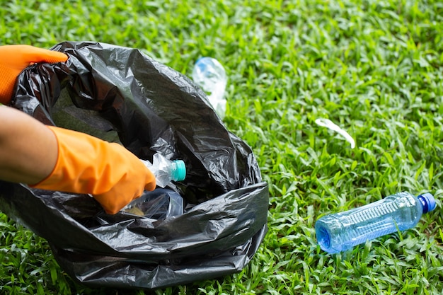 Kind ecofriendly volunteers holding packets and gathering plastic bottle garbage