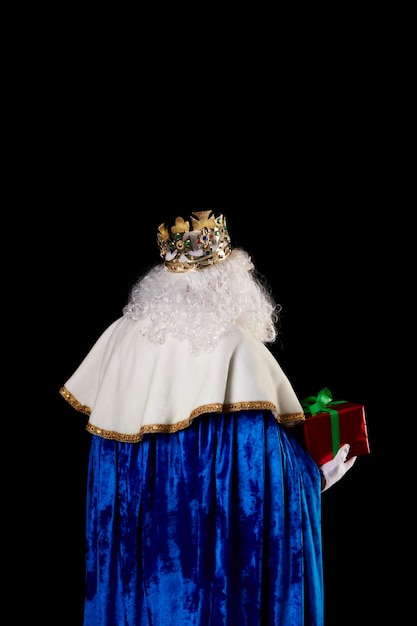 A king with an unrecognizable back gift on a black background