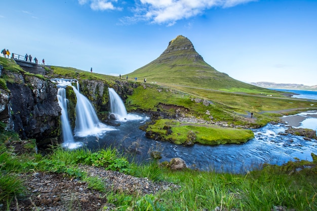 Kirkjufellsfoss, the most photographed mountain in Iceland, a long exposure and tourists visiting it