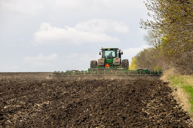 Kirovograd region, Ukraine - April 17, 2017: Farmer on tractor handles field on spring