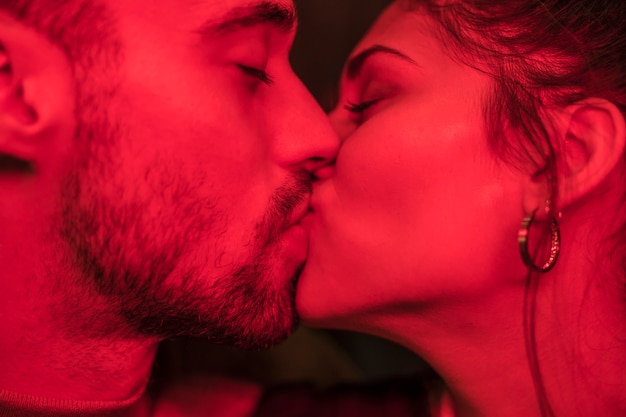 Photo kiss of young guy and attractive lady in redness