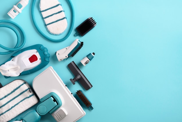 Kit of modern professional steam cleaners on blue background. 