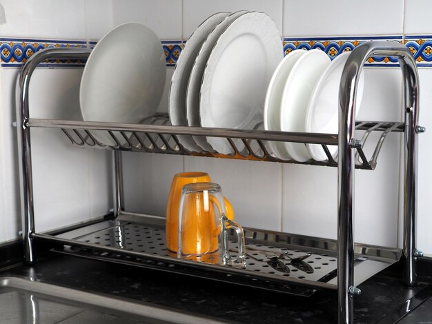 Kitchen dish dryer with clean plates and cups The concept of cleanliness and comfort