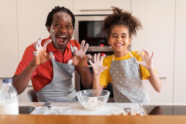 Kitchen Fun Cheerful Black Father And Daughter Fooling Together While Baking